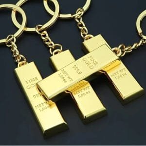 Metallic gold ingot keyring with the inscription "FINE GOLD 999,9 1 oz", simulating the shine of real gold.