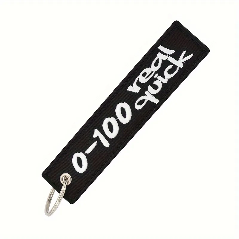 Schlüsselanhänger 0-100 Real Quick - schwarzes Material mit weißem gesticktem Schriftzug.