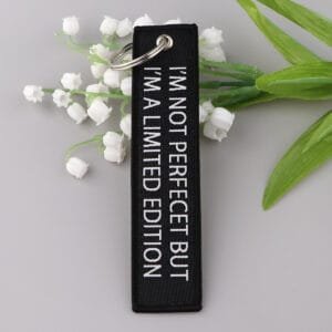 Limited Edition ripats - must materjal, millele on valge kirjaga tikitud "I'M NOT PERFECT BUT I'M A LIMITED EDITION".