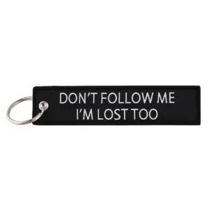 Medžiaginis raktų pakabukas su išsiuvinėta žinute „don't follow me I'm lost too“ ir apsiutais kraštais.