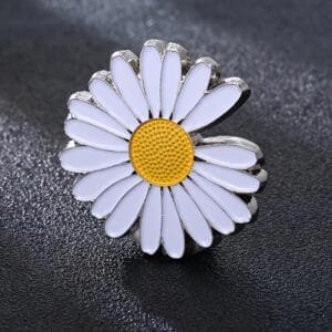 white daisy-shaped enamelled badge on a silver base