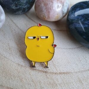 Bright yellow chicken with half-lidded eyes and an ironic expression enamel pin pin humour accessory