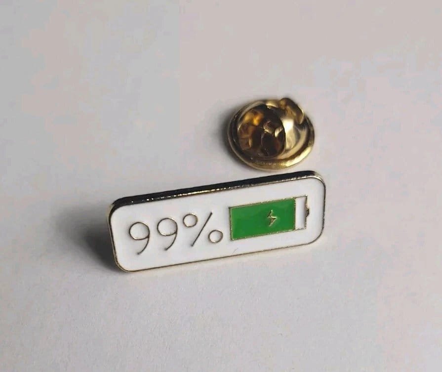 Horizontal white enamel pin with 99 per cent and green battery icon with lightning bolt symbol pin accessory